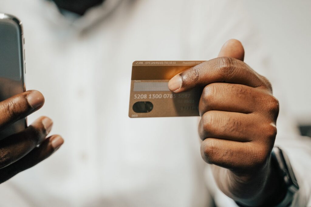 Pessoa usando smartphone e cartão de crédito para compra online